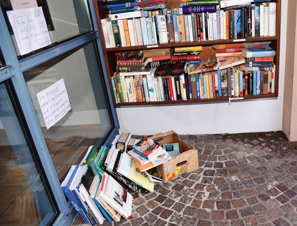 Weil die vermutlich gestohlene Bücherkiste immer noch fehlt, stehen die Bücher unterhalb des öffentlichen Bücherregals wieder auf dem Boden.